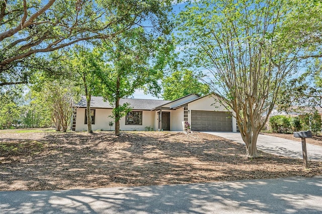 single story home with concrete driveway, stucco siding, and an attached garage
