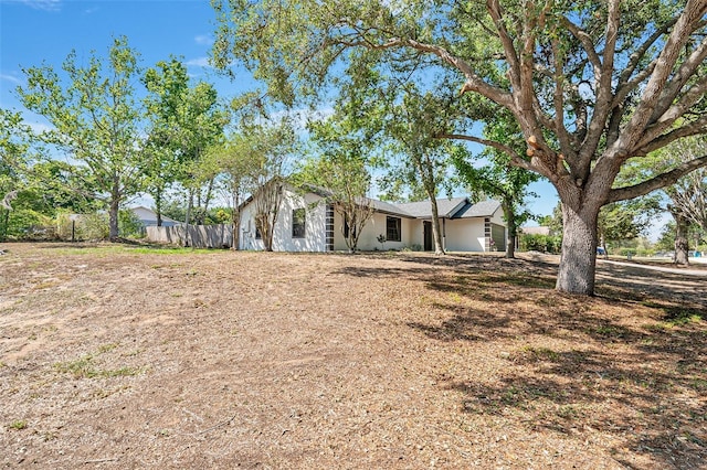 view of front of home with stucco siding and fence