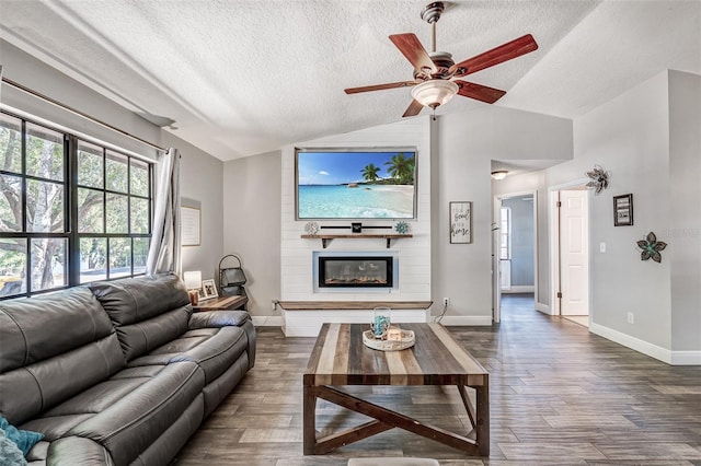 living room featuring dark wood finished floors, baseboards, and lofted ceiling