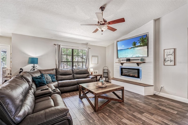 living room featuring dark wood-type flooring, ceiling fan, vaulted ceiling, and a textured ceiling