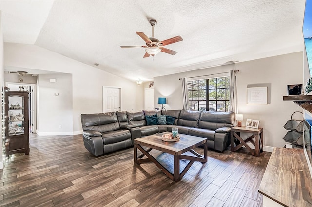 living room with baseboards, a ceiling fan, a textured ceiling, dark wood-style floors, and vaulted ceiling