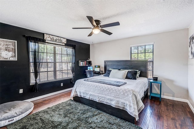 bedroom with baseboards, a ceiling fan, wood finished floors, and a textured ceiling