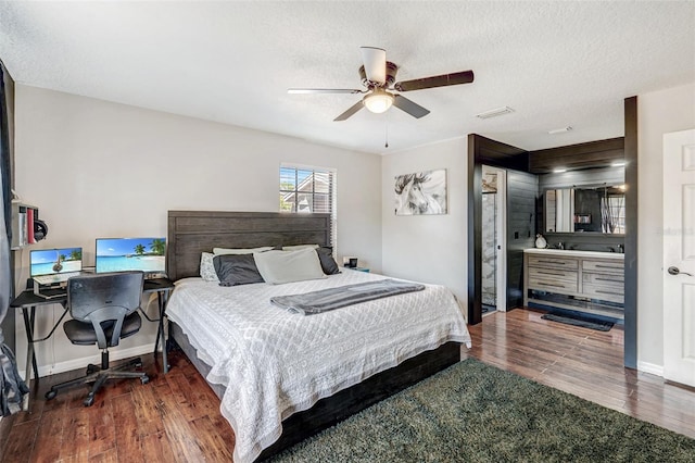 bedroom with baseboards, a textured ceiling, a ceiling fan, visible vents, and wood finished floors
