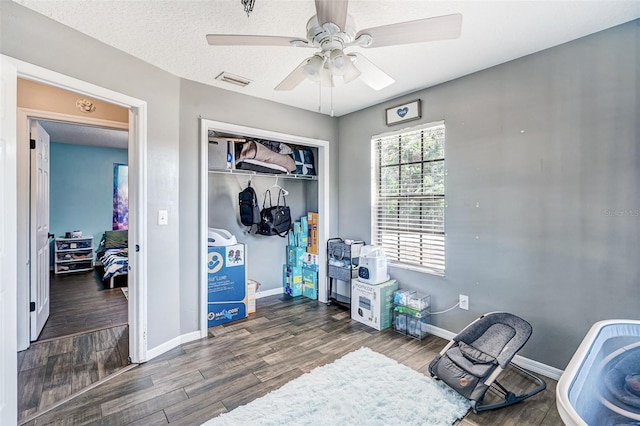 bedroom with visible vents, baseboards, a closet, ceiling fan, and wood finished floors