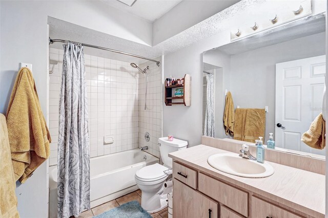 bathroom with tile patterned floors, toilet, vanity, and shower / bath combination with curtain