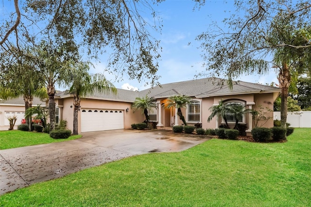 ranch-style home with an attached garage, a front lawn, fence, stucco siding, and driveway