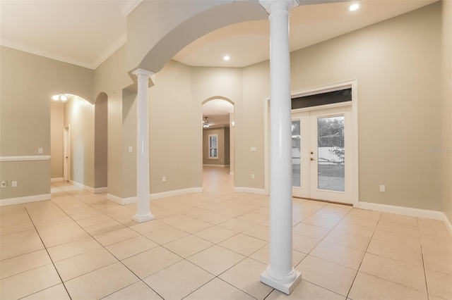 empty room with light tile patterned floors, french doors, baseboards, and ornamental molding