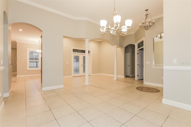 empty room featuring a chandelier, light tile patterned floors, arched walkways, and crown molding