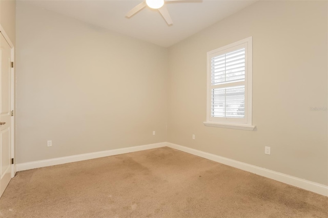 spare room featuring carpet flooring, baseboards, and ceiling fan