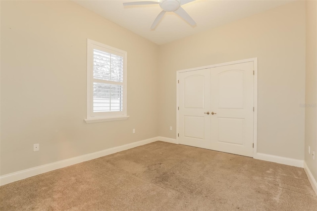 unfurnished bedroom featuring a closet, baseboards, a ceiling fan, and carpet flooring