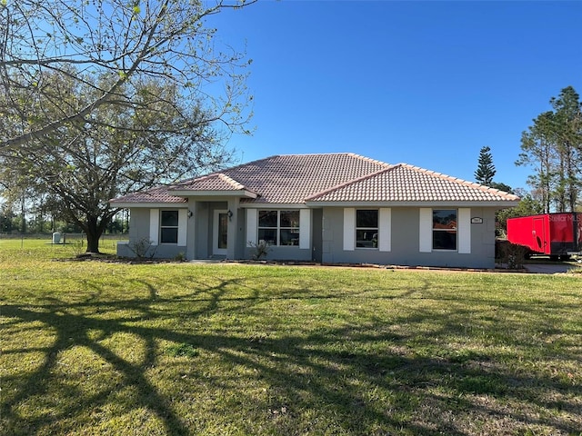 view of front of property featuring a front lawn and a tile roof