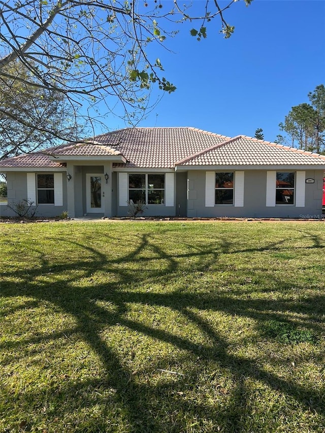 view of front facade with a front lawn and a tile roof