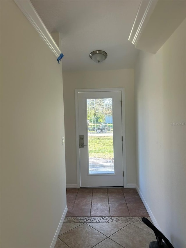 doorway to outside with light tile patterned flooring and baseboards