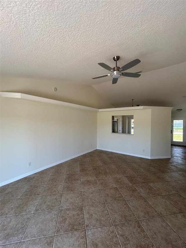 unfurnished room with lofted ceiling, dark tile patterned flooring, a ceiling fan, and baseboards