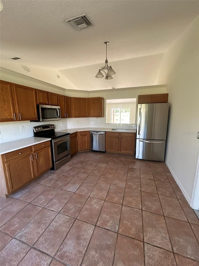 kitchen with visible vents, light countertops, lofted ceiling, brown cabinets, and appliances with stainless steel finishes