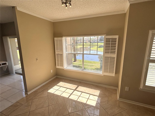 tiled empty room with a textured ceiling, crown molding, and baseboards