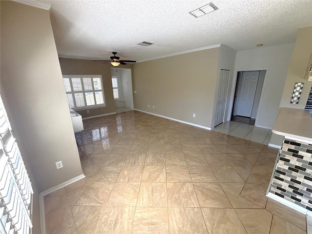 empty room featuring a textured ceiling, baseboards, visible vents, and ceiling fan