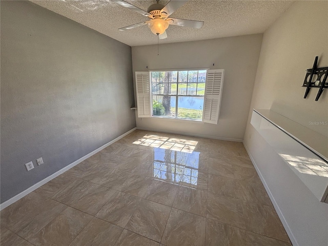 spare room with a textured ceiling, baseboards, and ceiling fan