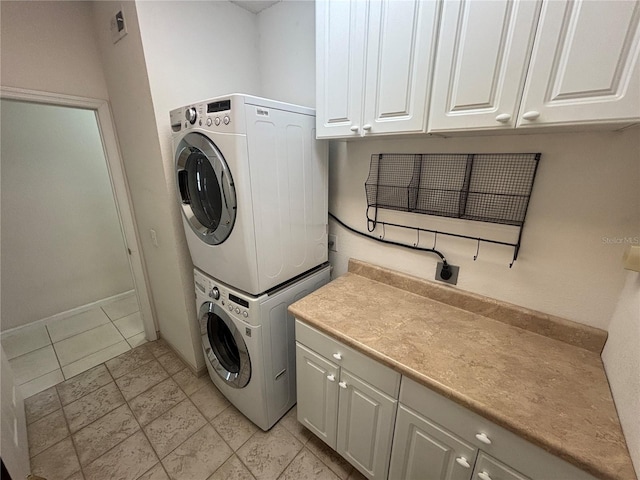 laundry room featuring cabinet space and stacked washer and clothes dryer