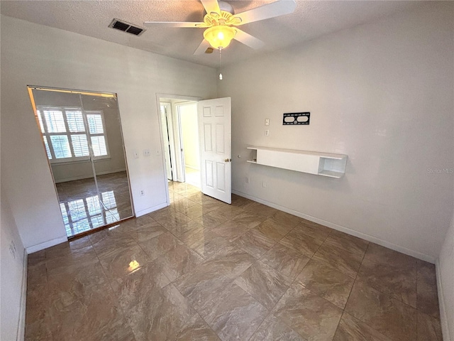 unfurnished room with visible vents, a textured ceiling, baseboards, and ceiling fan