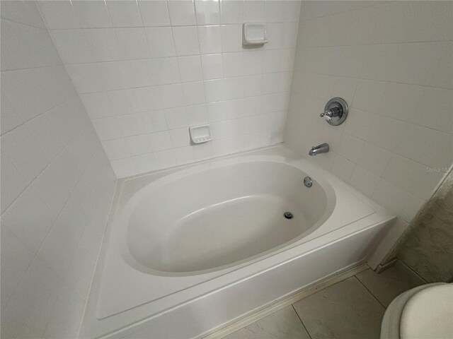 full bathroom featuring toilet and tile patterned flooring