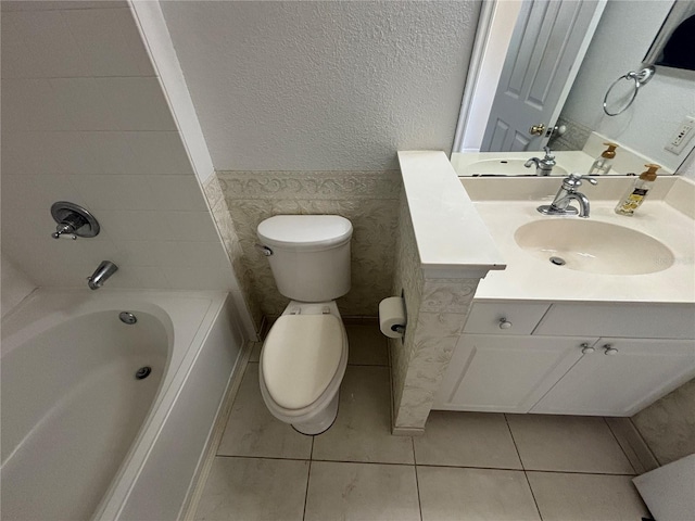 full bath featuring tile patterned flooring, toilet, shower / tub combination, a textured wall, and vanity