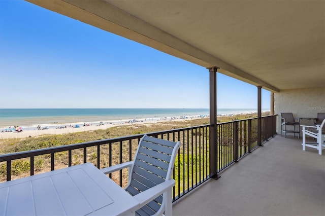 balcony featuring a water view and a view of the beach