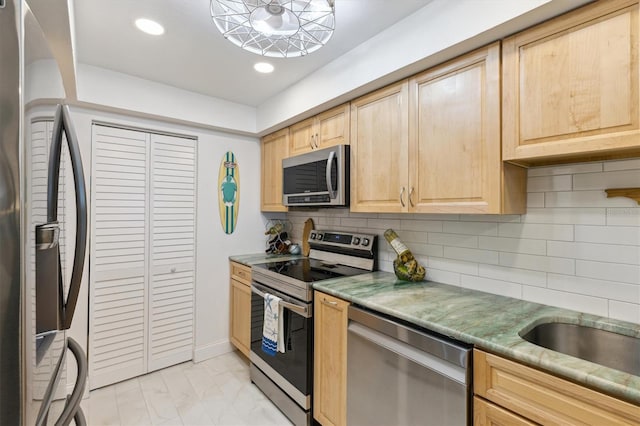 kitchen featuring marble finish floor, light brown cabinets, tasteful backsplash, recessed lighting, and appliances with stainless steel finishes