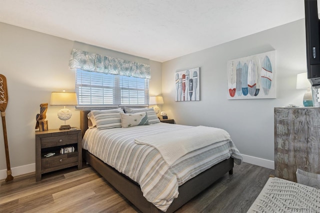 bedroom with wood finished floors and baseboards