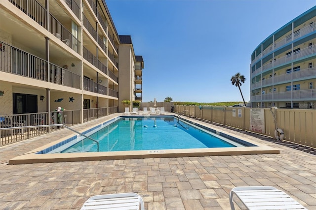 community pool featuring a patio and fence