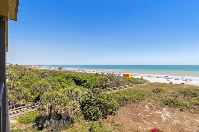 view of water feature featuring a beach view and fence