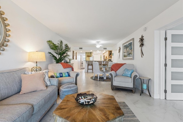 living area with marble finish floor and ceiling fan