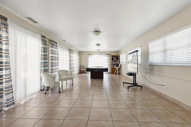 unfurnished room featuring light tile patterned floors, visible vents, and baseboards