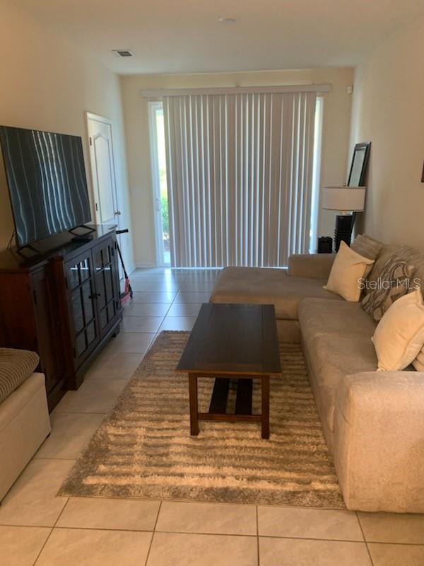 living area with light tile patterned floors and visible vents