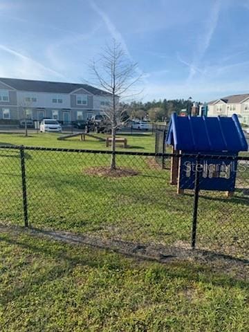 view of home's community with a yard and fence