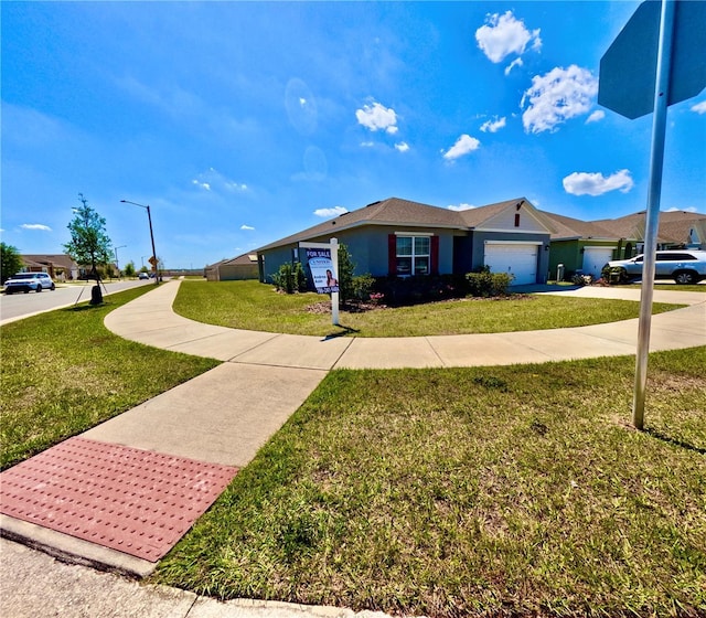 ranch-style house with an attached garage, concrete driveway, and a front yard