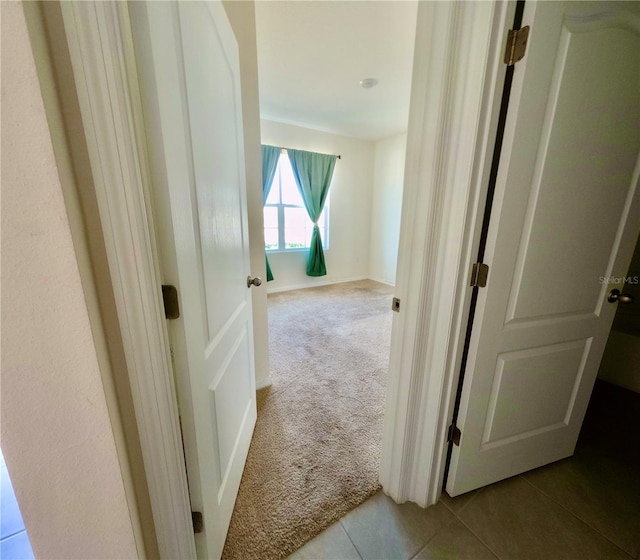 corridor with tile patterned floors and carpet floors