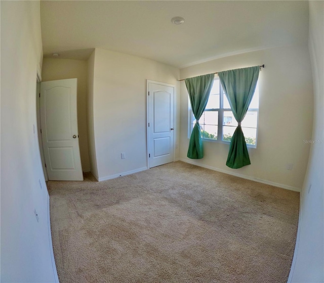 spare room with carpet flooring and baseboards