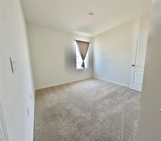 unfurnished room with baseboards and carpet floors