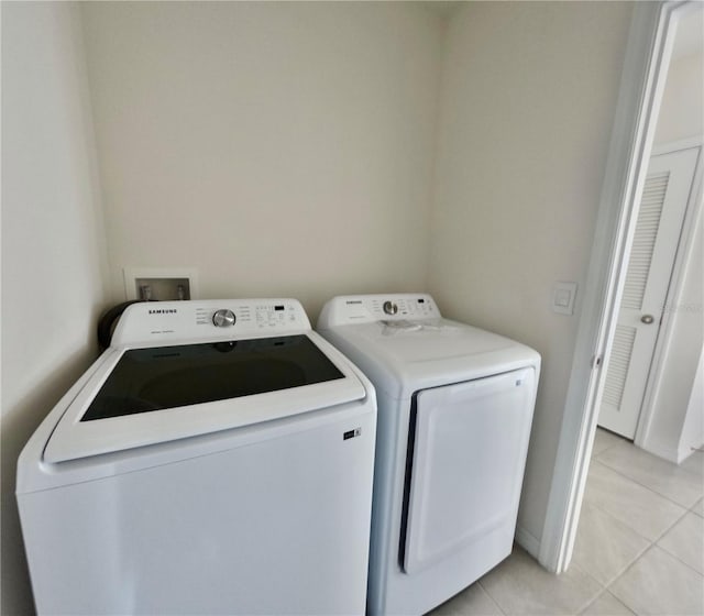 laundry area with light tile patterned floors and washing machine and dryer