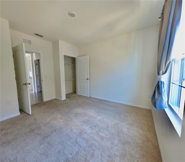 unfurnished bedroom featuring visible vents, baseboards, and carpet