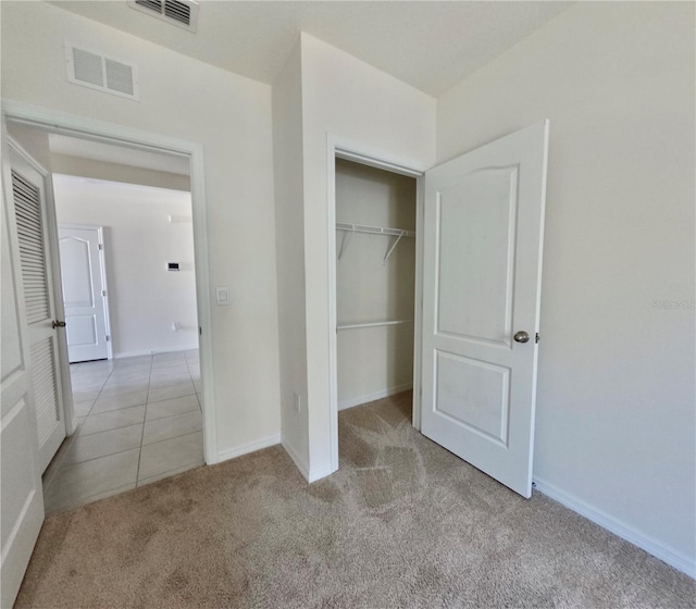 unfurnished bedroom featuring a closet, visible vents, carpet flooring, and baseboards