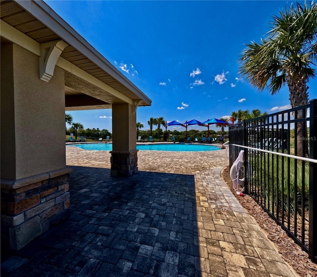 view of patio / terrace featuring fence and a community pool