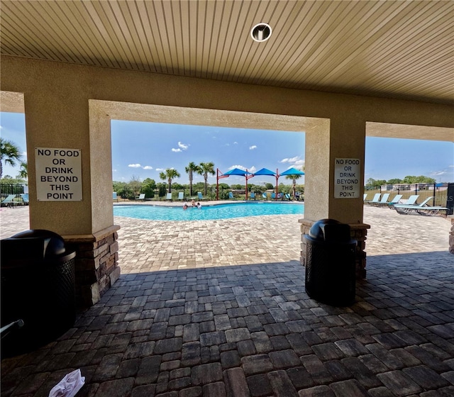 view of patio / terrace featuring a community pool and a grill