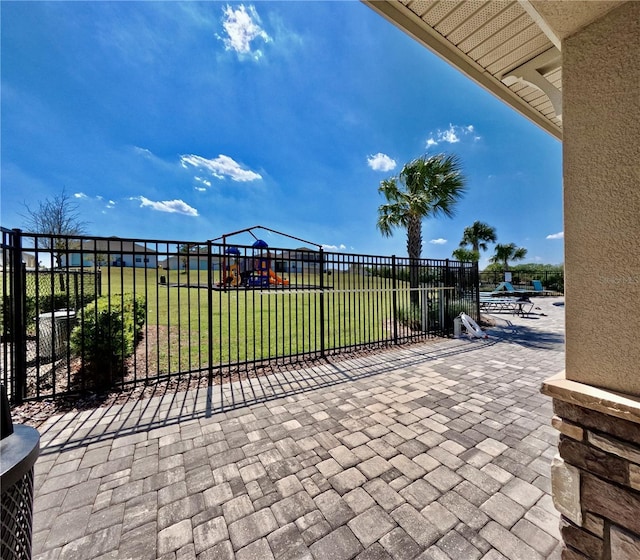 view of patio / terrace featuring playground community and fence