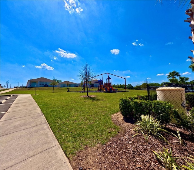 view of home's community featuring a lawn and playground community