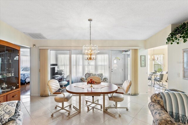 3748 Innisbrook Dr, Lakeland, FL 33810 - dining area with a chandelier, a textured ceiling, light tile patterned floors, and baseboards
