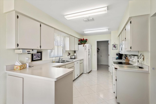 3748 Innisbrook Dr, Lakeland, FL 33810 - kitchen with white appliances, a sink, a peninsula, light countertops, and light tile patterned floors