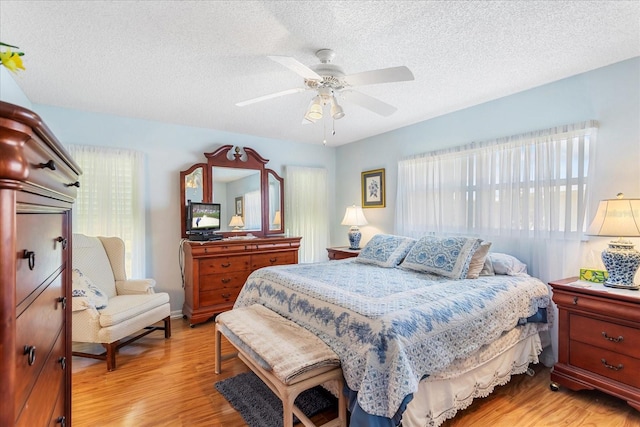 3748 Innisbrook Dr, Lakeland, FL 33810 - bedroom with light wood-type flooring, a textured ceiling, and a ceiling fan