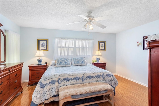3748 Innisbrook Dr, Lakeland, FL 33810 - bedroom featuring light wood-style floors, a textured ceiling, baseboards, and a ceiling fan